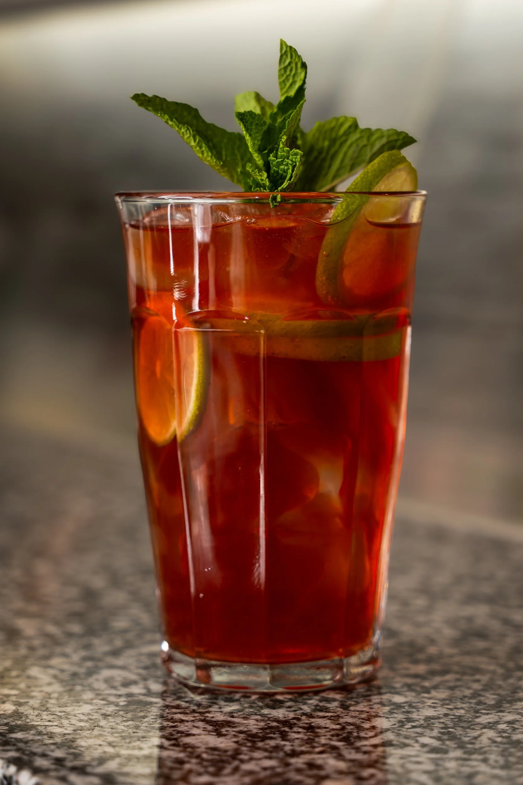 Iced red Thai tea with fresh mint on a terrazzo counter at WOK Copenhagen – food photography by Mondays Photo