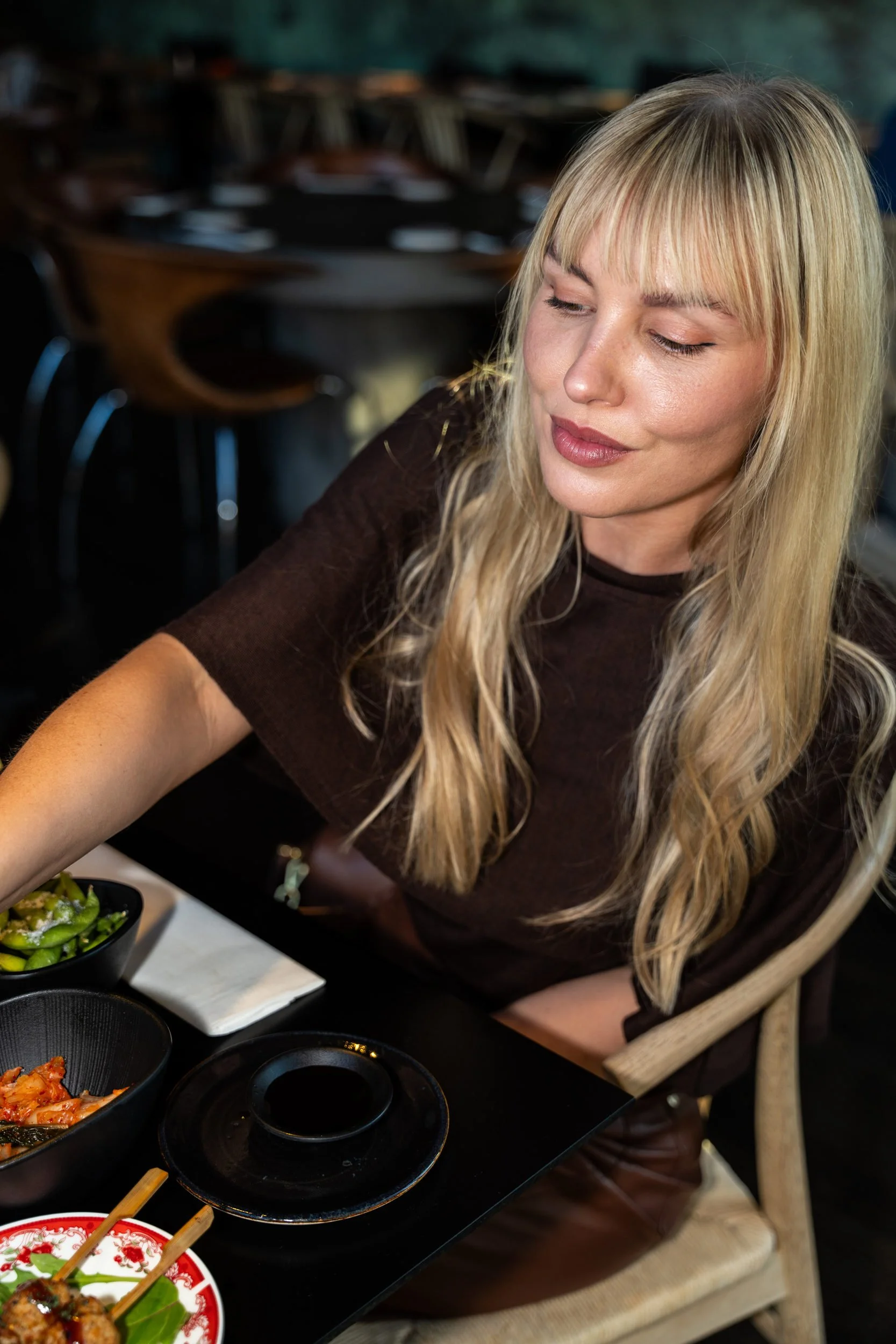 Gæst ved et bord fyldt med sushi og cocktails i restauranten hos Sushi Lab København