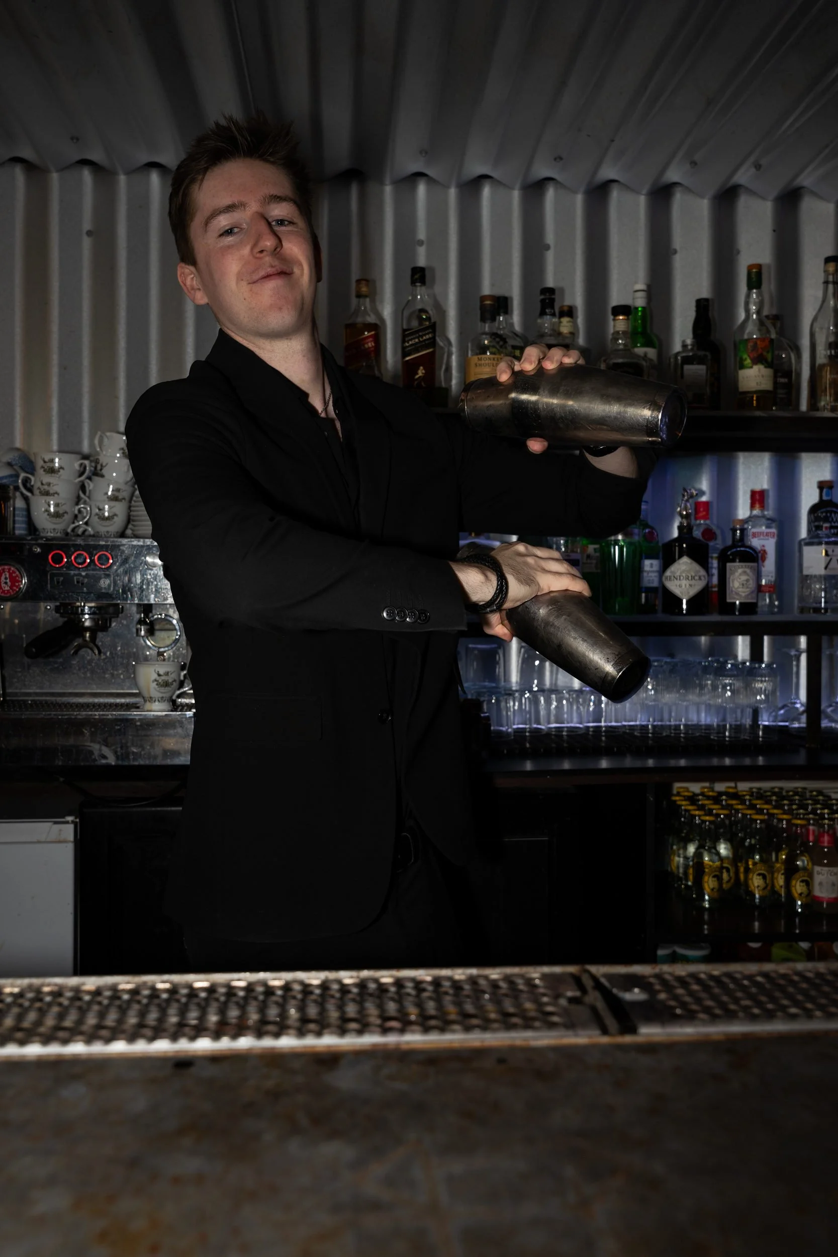 Bartender ryster en cocktail med to shakere bag baren på Little Green Door