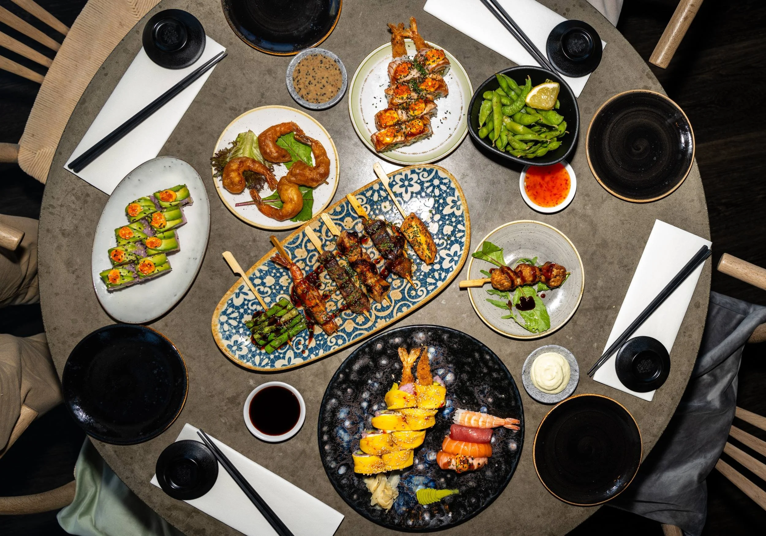 Sushibord set ovenfra på Sushi Lab København med maki-ruller, sticks, edamame, dips og små skåle