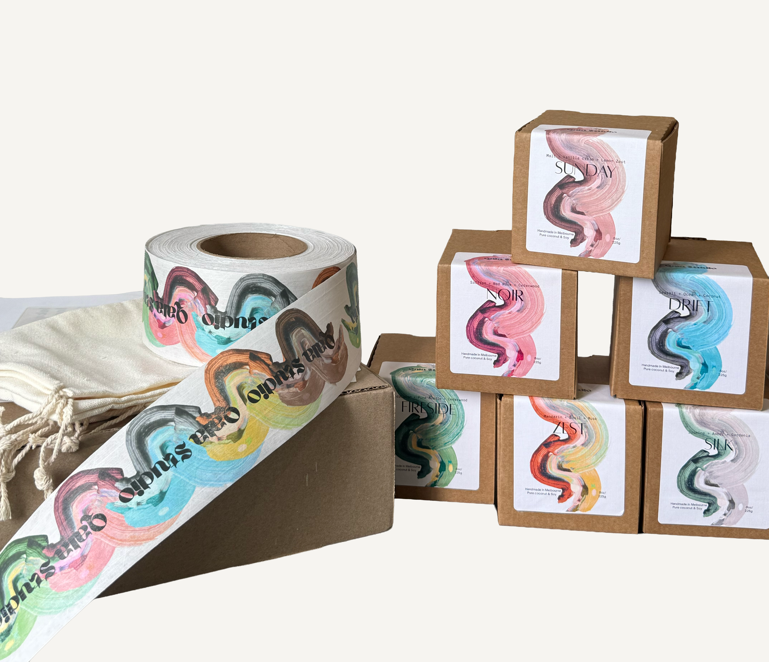 Box of colorful printed tape rolls and small brown boxes with abstract art labels.