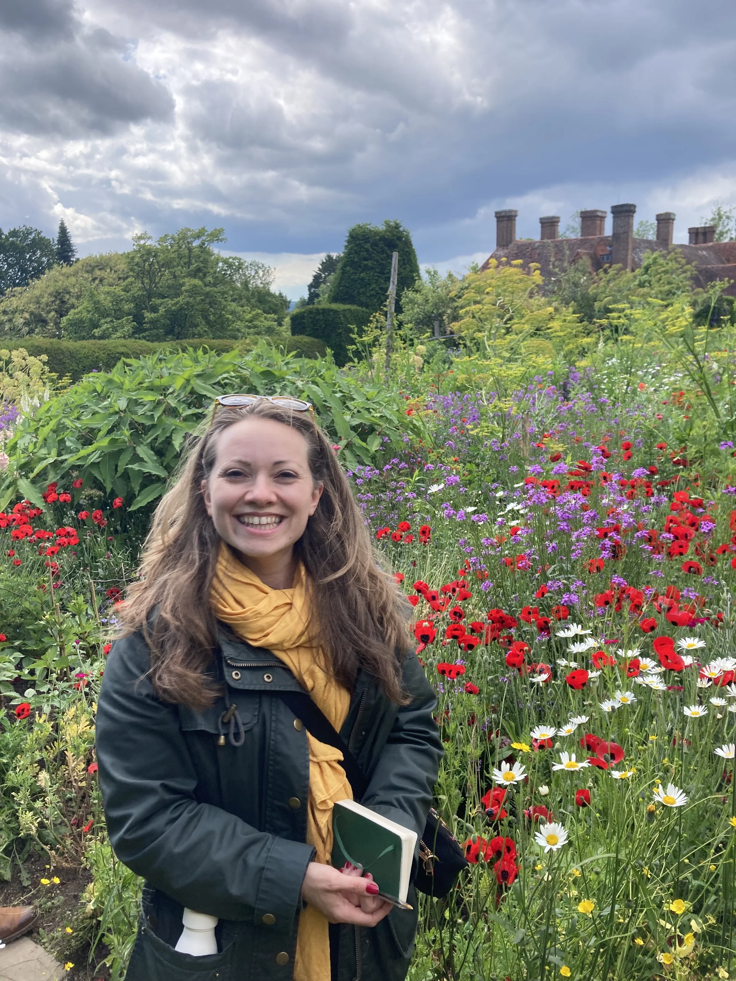Katy Noon standing in front of a colourful mixed flower bed