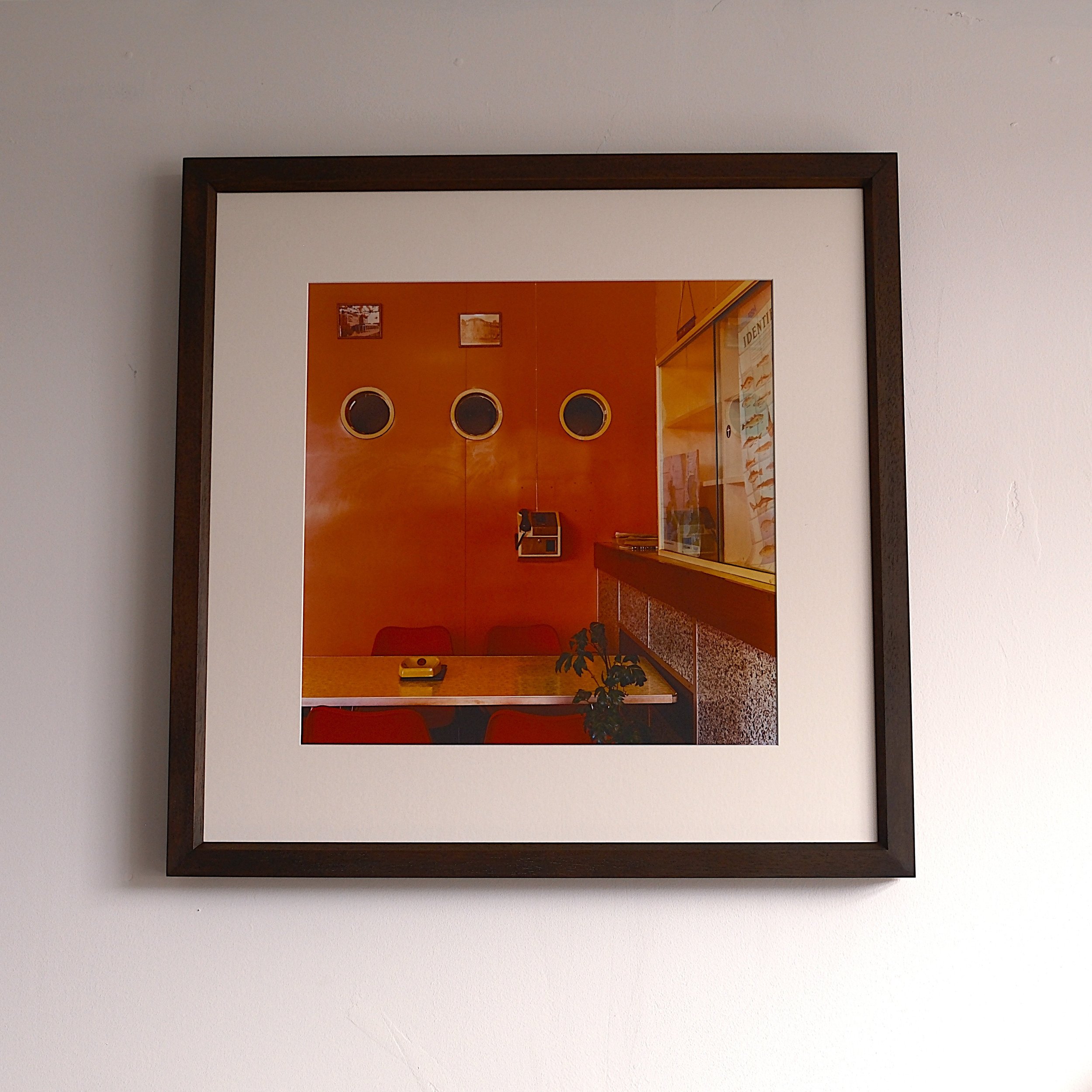 Photo of a wall with three round windows and a countertop.