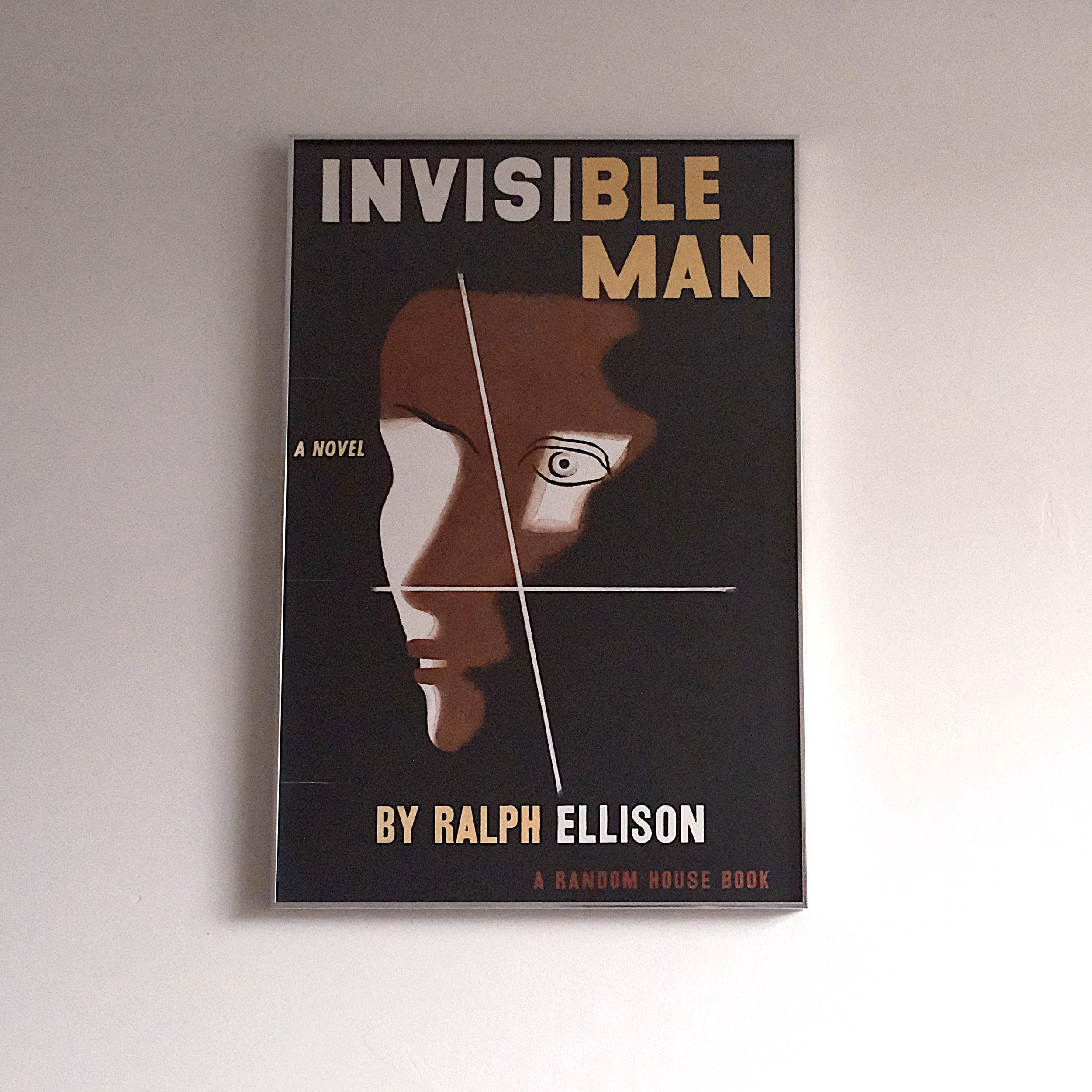 Book cover for 'Invisible Man' by Ralph Ellison, featuring stylized illustration of a man's face with a focus on eye and profile, set against a dark background.