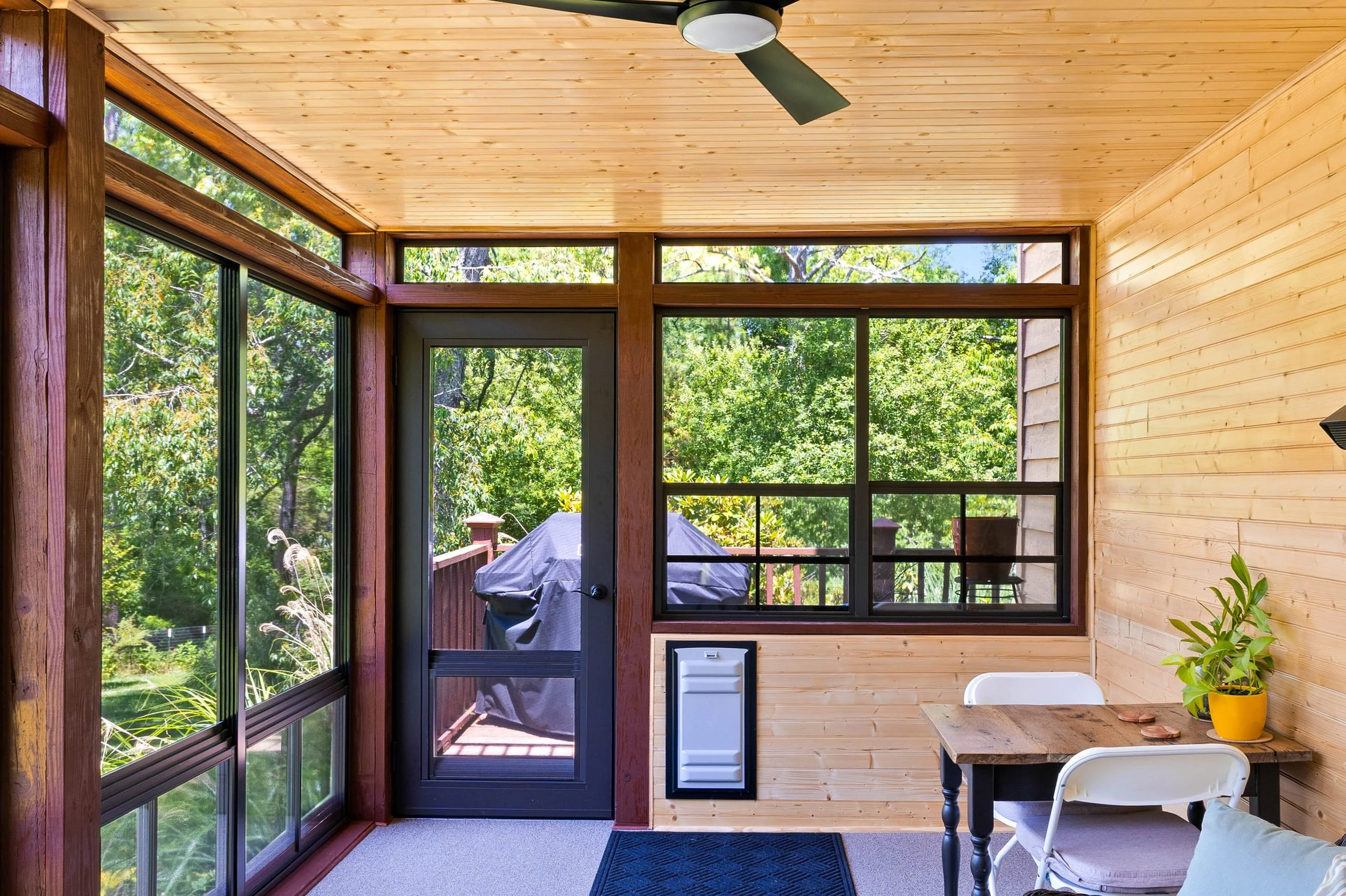 Built-in dog door providing access from a three-season room to the backyard.
