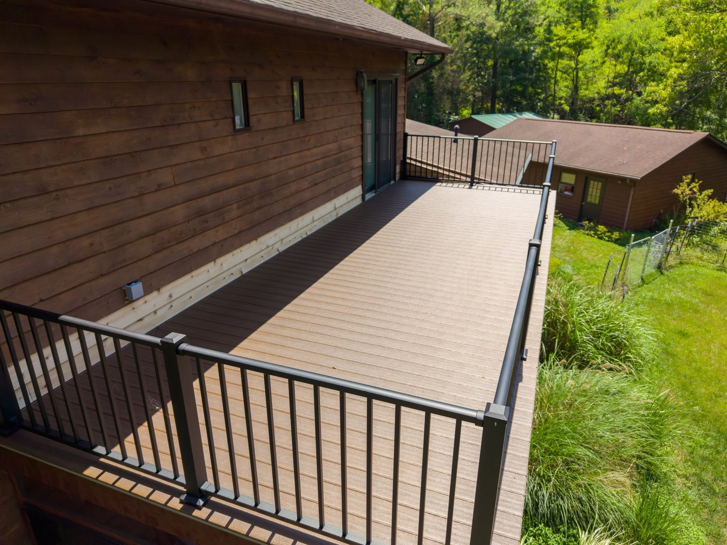 Close-up of Duxxback waterproof deck boards installed above a three-season room.