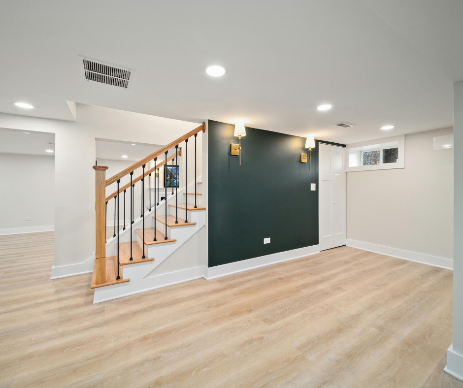 Finished basement with stairs leading into the room and a feature wall for a TV and bookcases