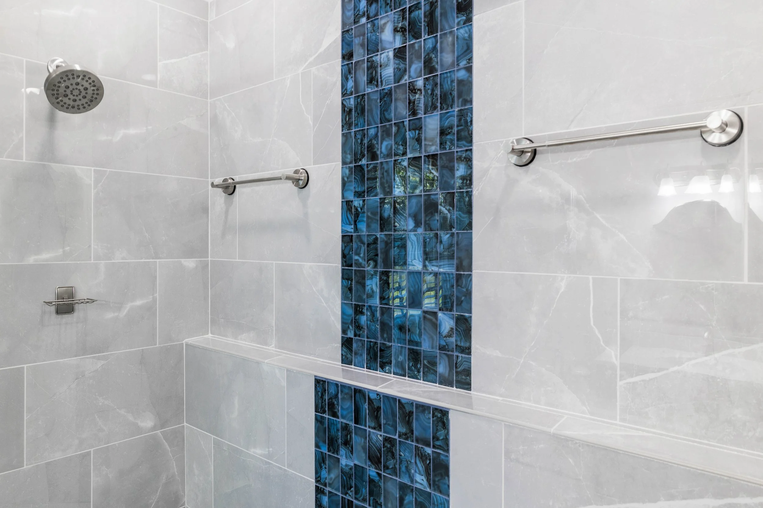 Blue Onyx waterfall-style accent alongside gray Lava Matte tile in the walk-in shower.