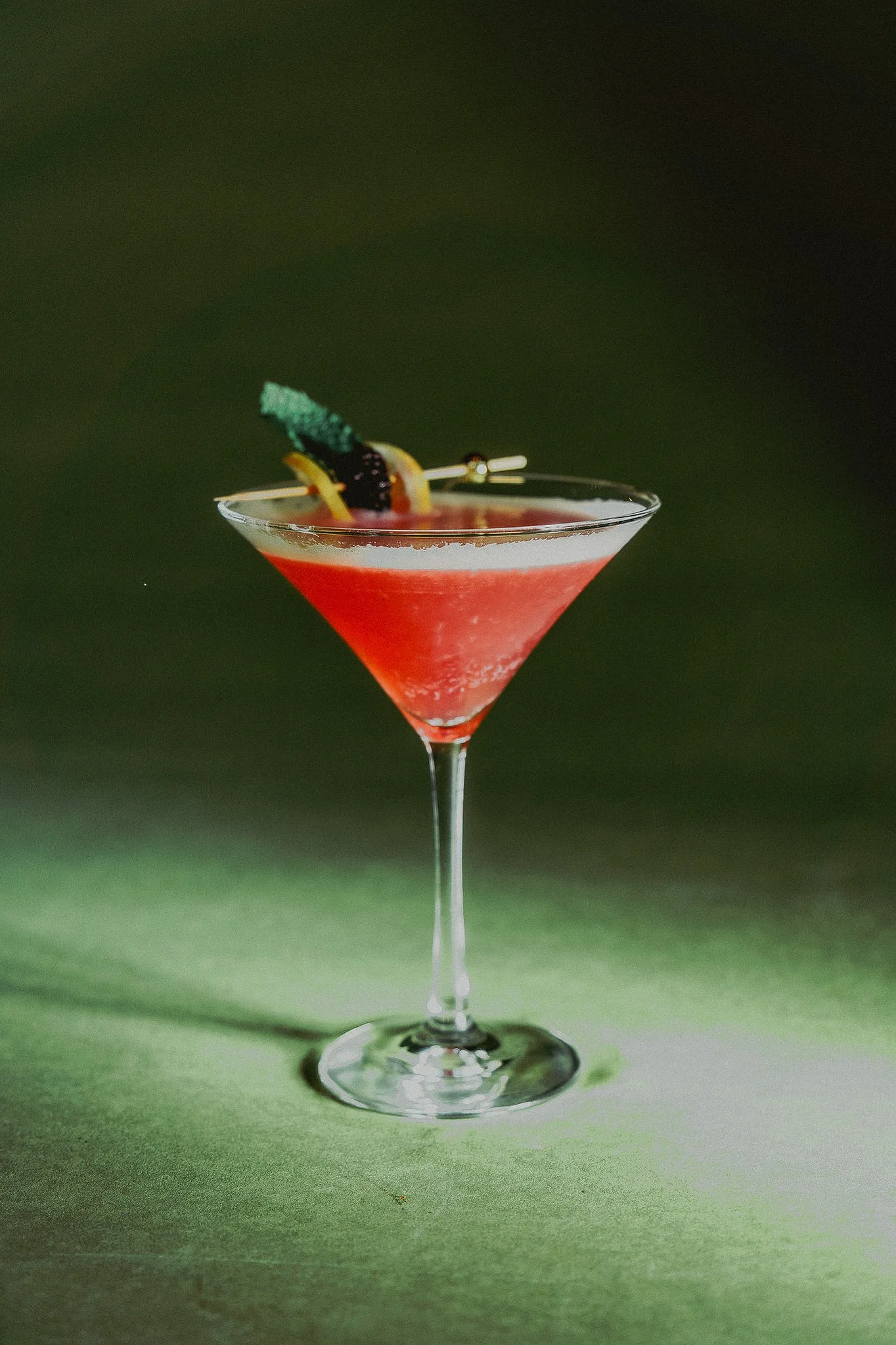 Handcrafted Italian martini at The Rossi Kitchen + Bar in Columbus, Ohio, featuring a vibrant red cocktail with citrus and herb garnish.