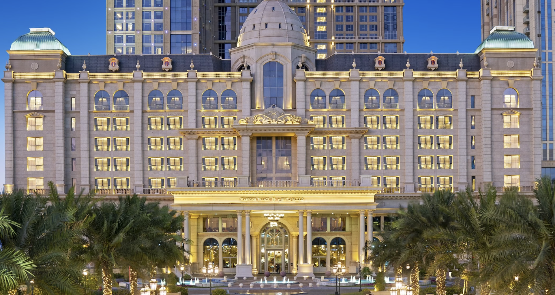 Luxurious hotel exterior with ornate architecture and palm trees in the foreground.