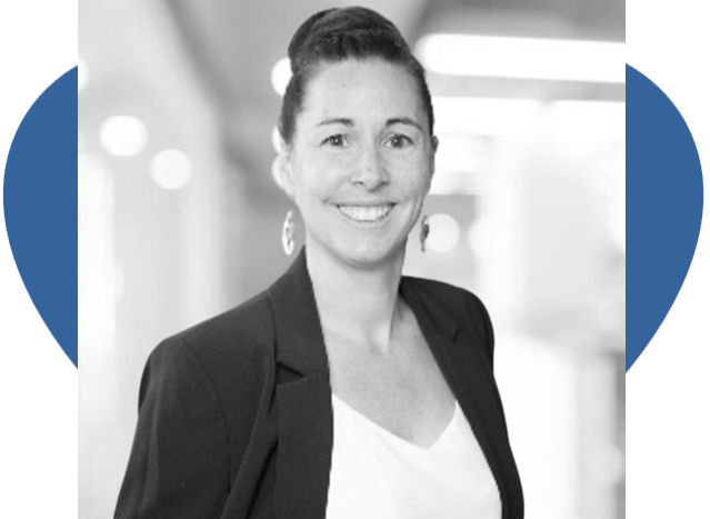 Portrait en noir et blanc d'une femme souriante aux cheveux longs, portant un blazer sombre et des boucles d'oreilles.
