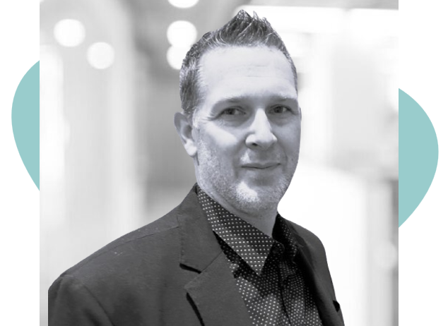 Homme souriant en tenue de travail sur fond flou, photo en noir et blanc.