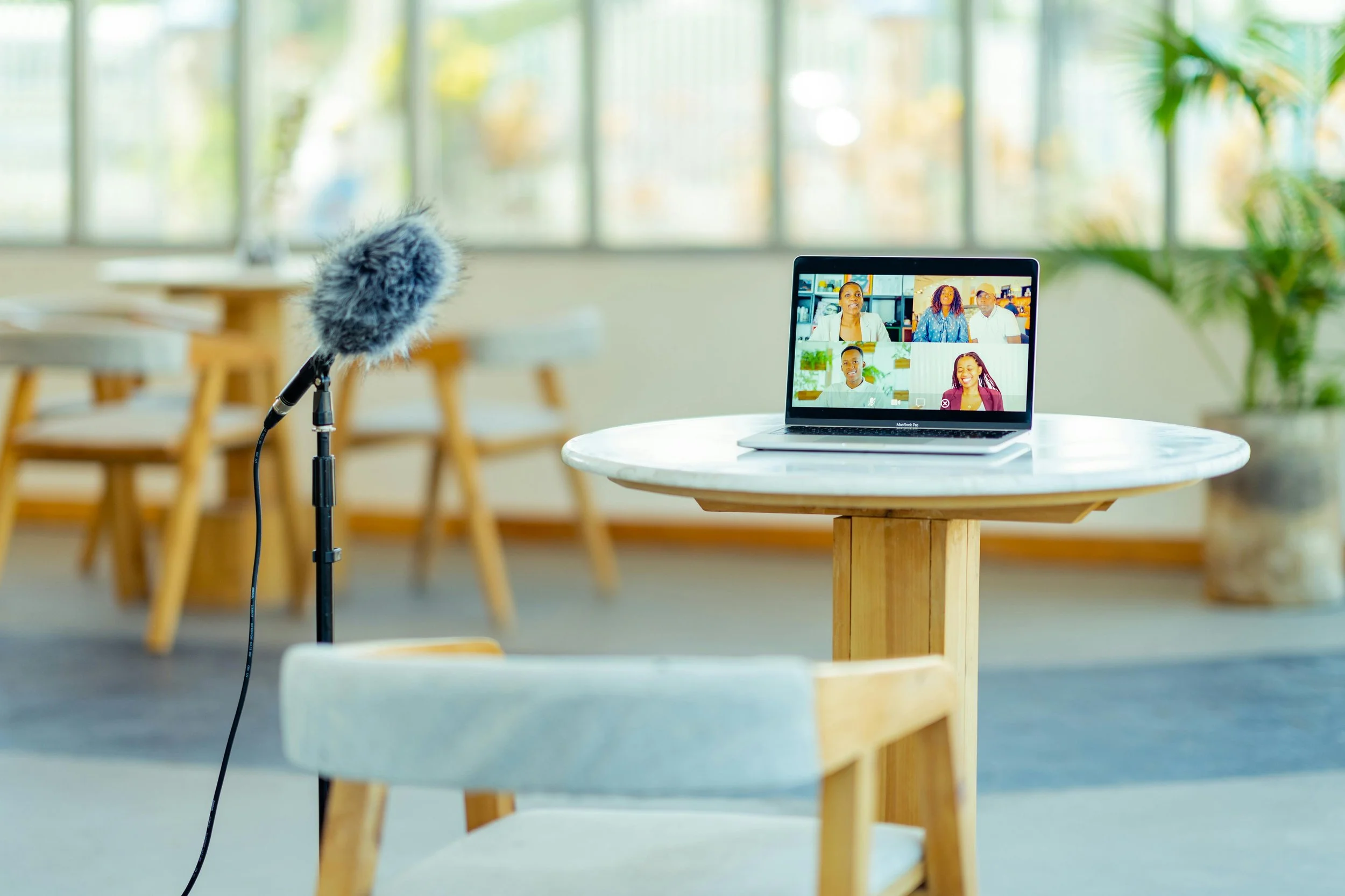 A mic sits in front of a table with a computer ready to start a virtual meeting