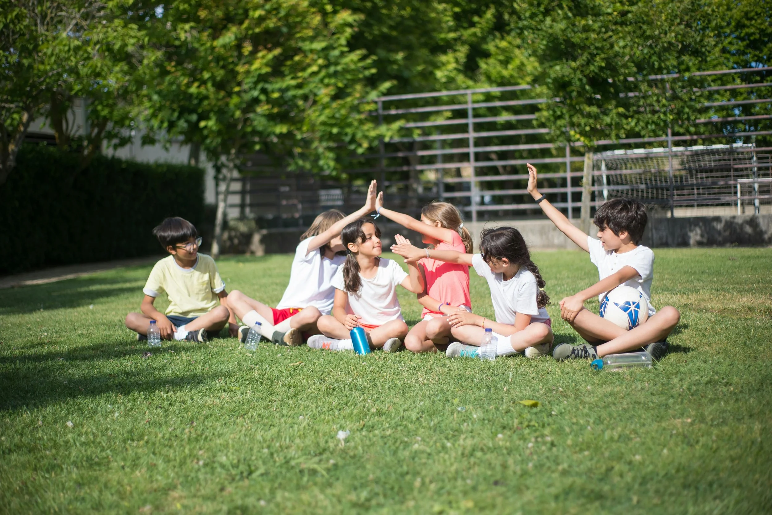 A group of kids high-five outside