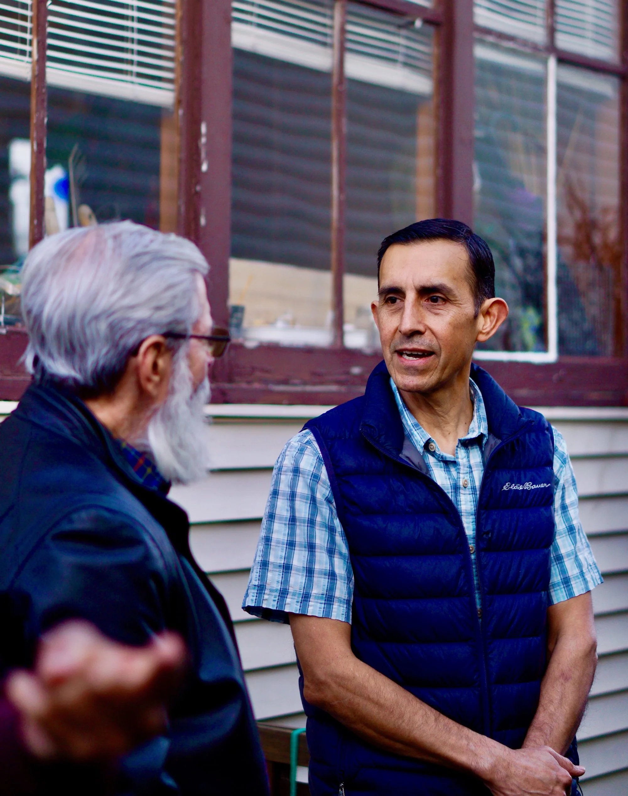 Samuel Hurtado having a conversation with a community member outside at an event.