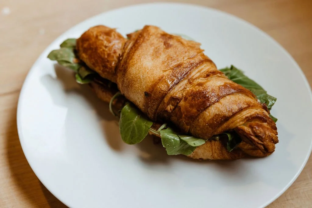 Croissant sandwich with greens on a plate