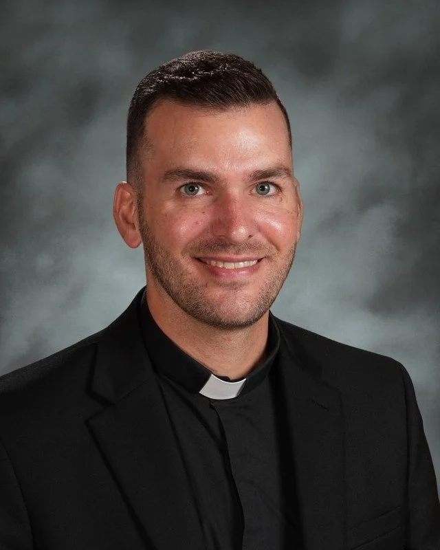 Smiling elderly man wearing clergy clothing and glasses