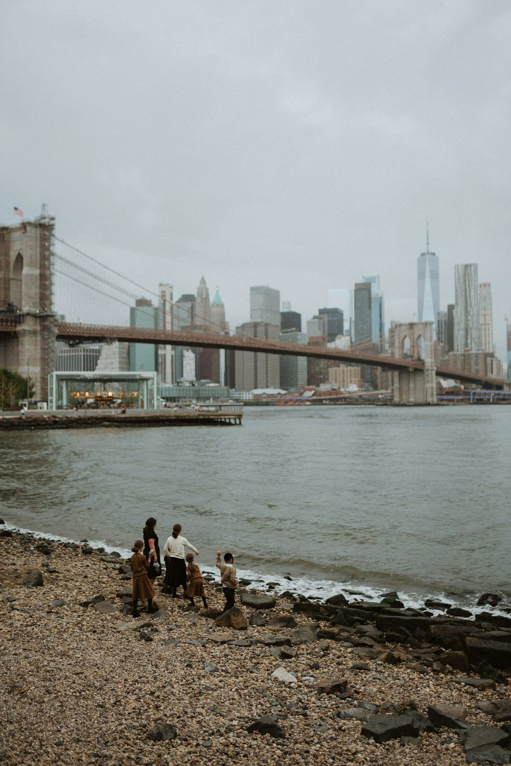Family standing together near a New York City bridge representing connection and family relationships