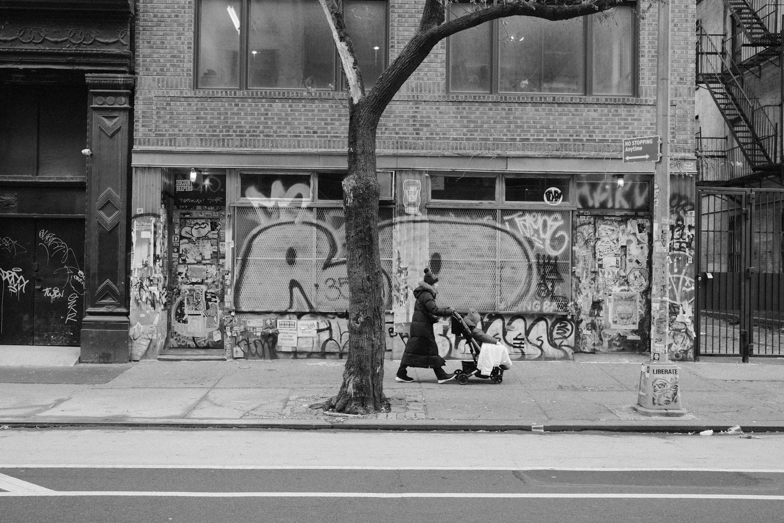 Parent pushing a stroller on a Brooklyn sidewalk, reflecting the emotional and life changes that come with parenthood.
