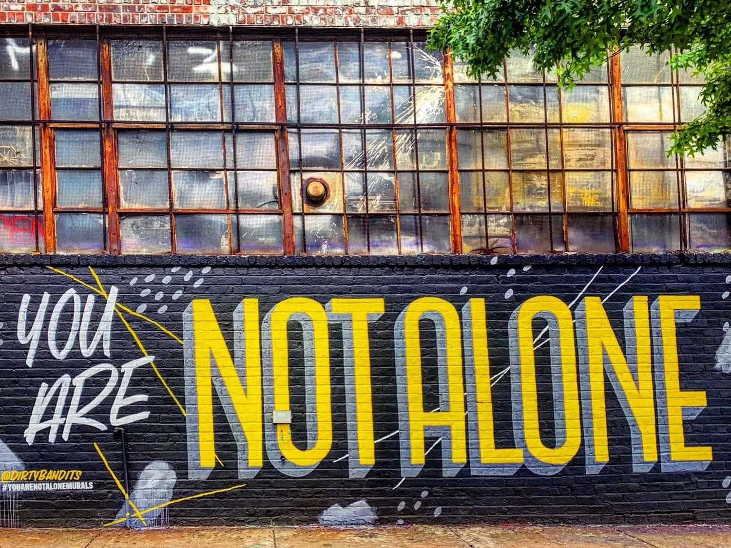 Mural displaying the words 'You Are Not Alone' featured on a teen therapy page