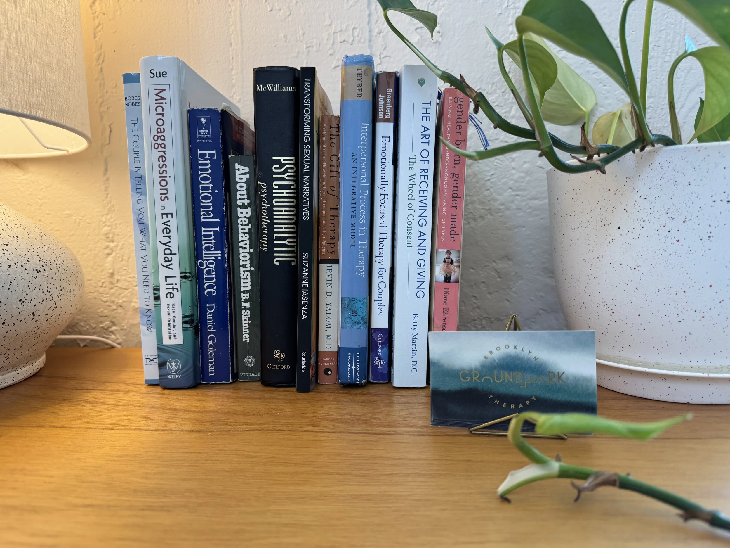 Books on a desk with Groundwork Therapy business card in a welcoming Brooklyn therapy office