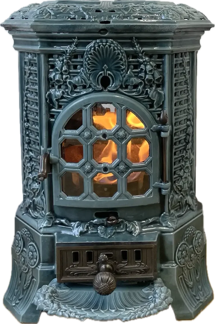 Ornate cast iron stove with intricate floral designs and a visible fire behind a decorative glass door.