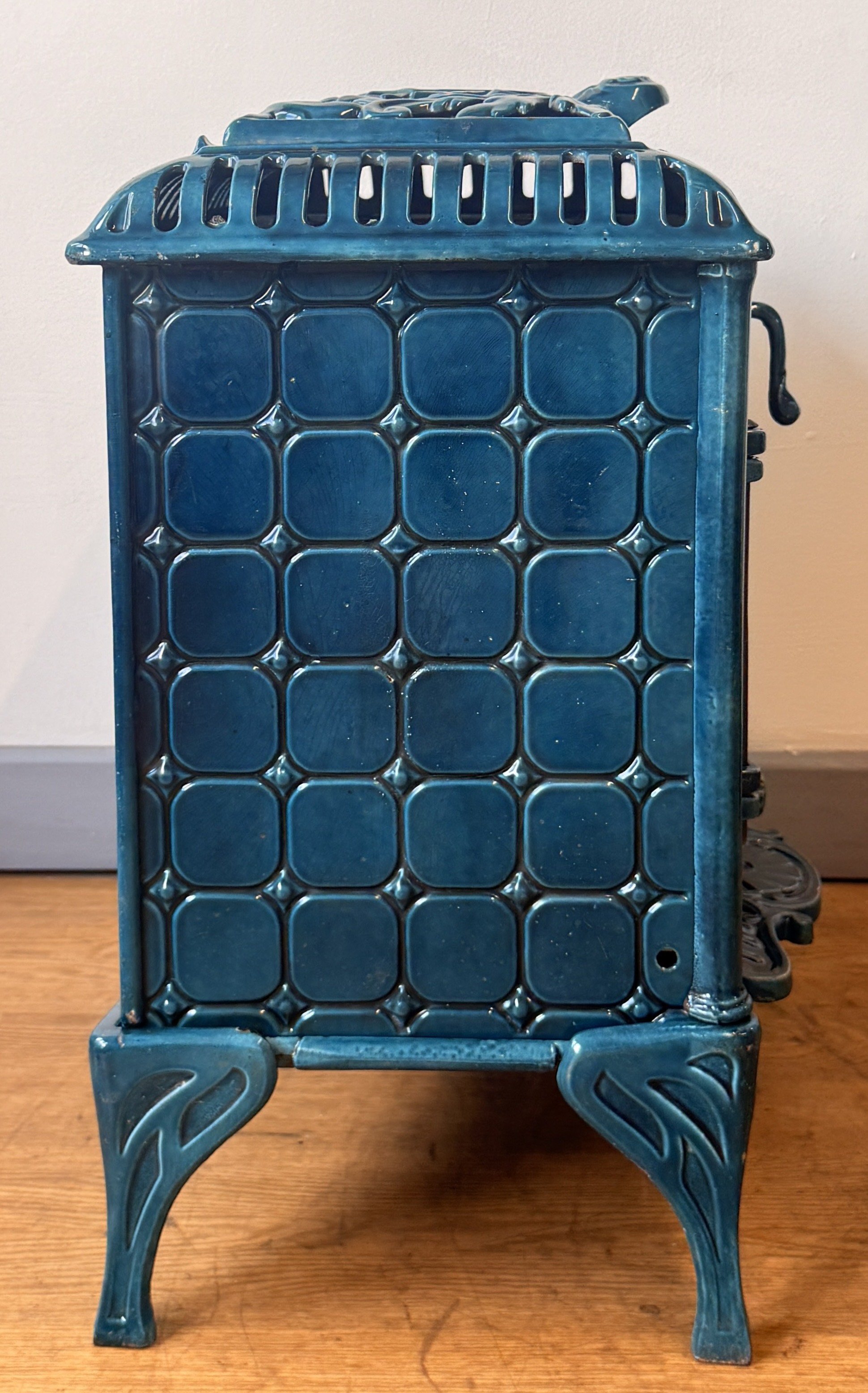Side view of a cast iron stove with square pattern