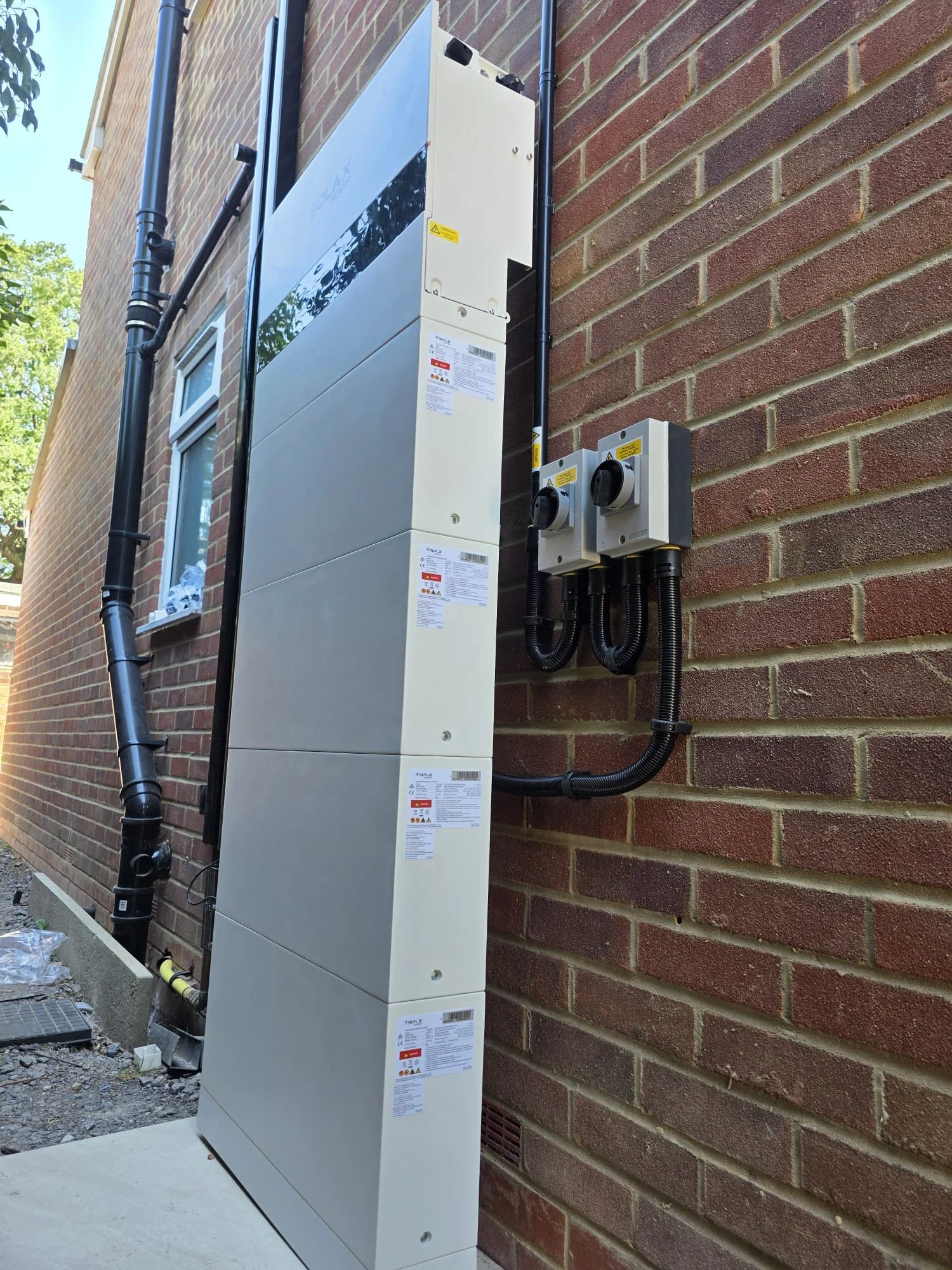 Electrical or utility box mounted on an exterior brick wall of a building.
