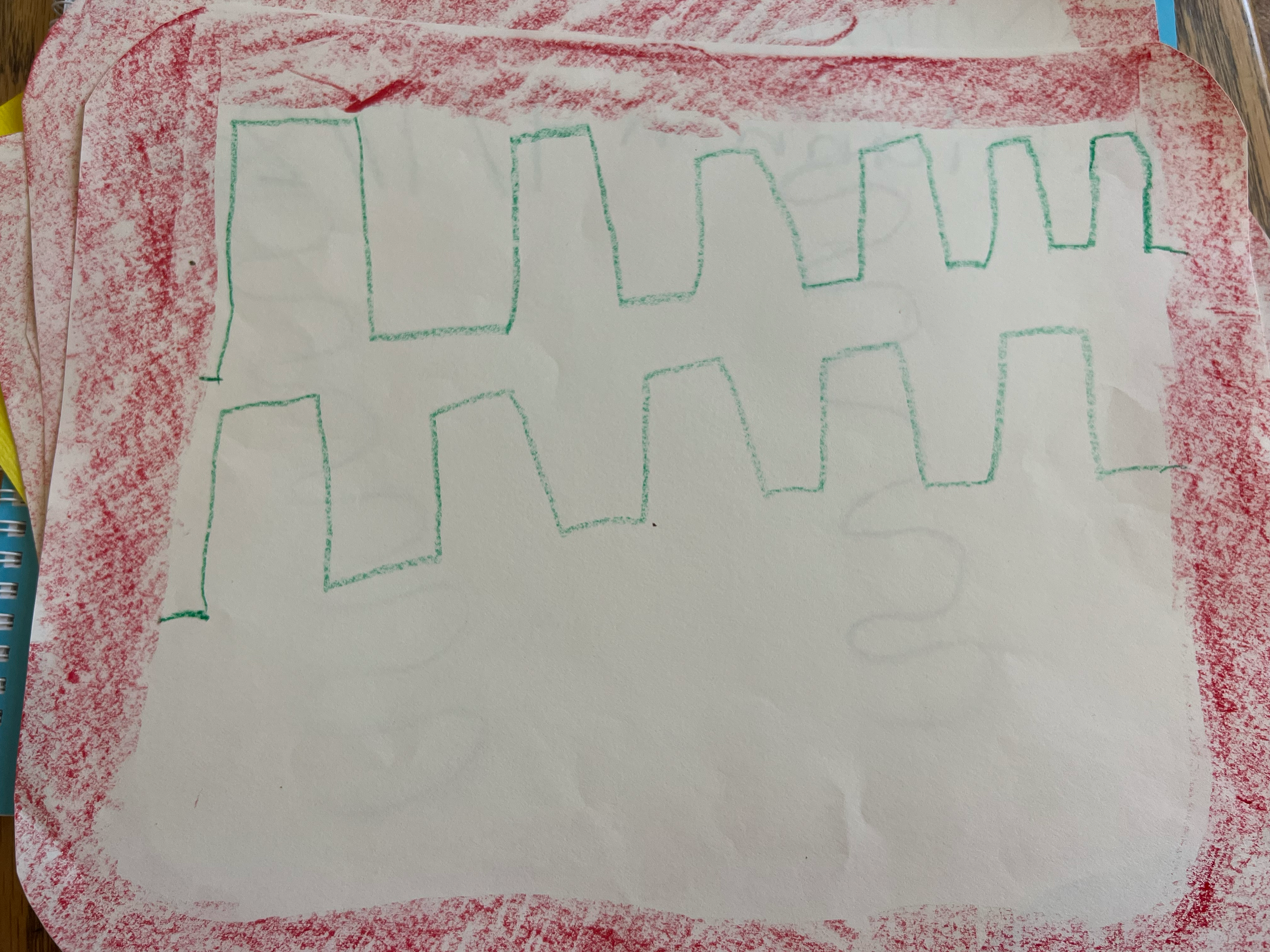 A white piece of paper with a red border and green drawn zigzag lines.