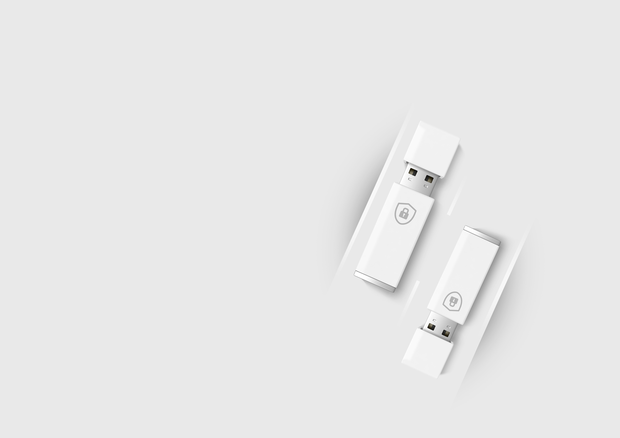 Two white USB security keys with lock icons on them, placed diagonally on a light gray surface.