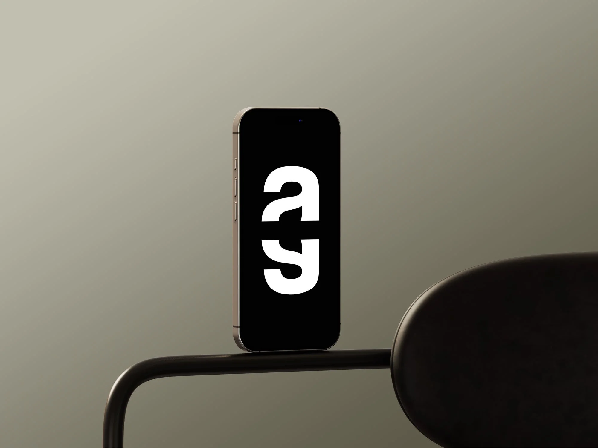 A smartphone displaying the letter 'A' upside down on a black background, placed on a black metal surface.