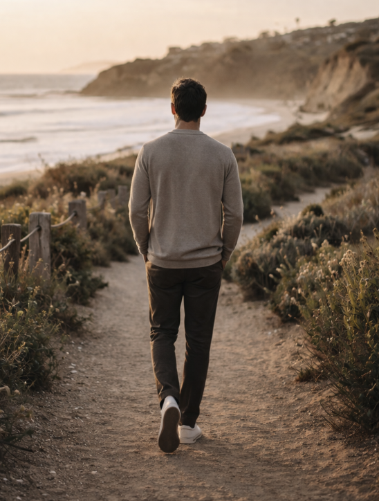 Men’s therapy and support for life transitions in San Clemente, shown through a man walking along the beach in a calm, reflective setting.