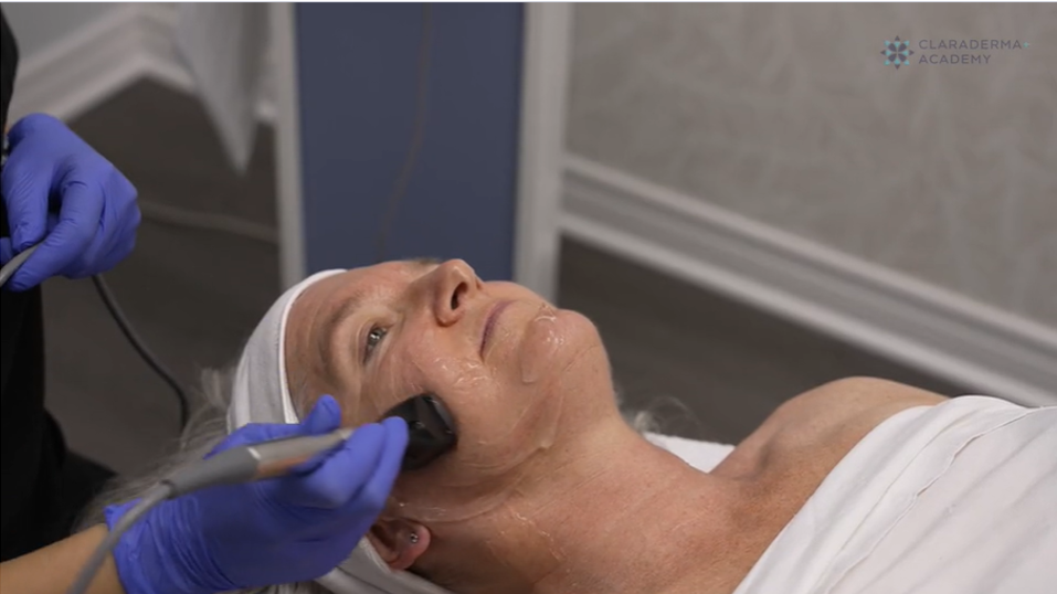 A woman receiving a facial treatment with a device in a spa or skincare clinic.