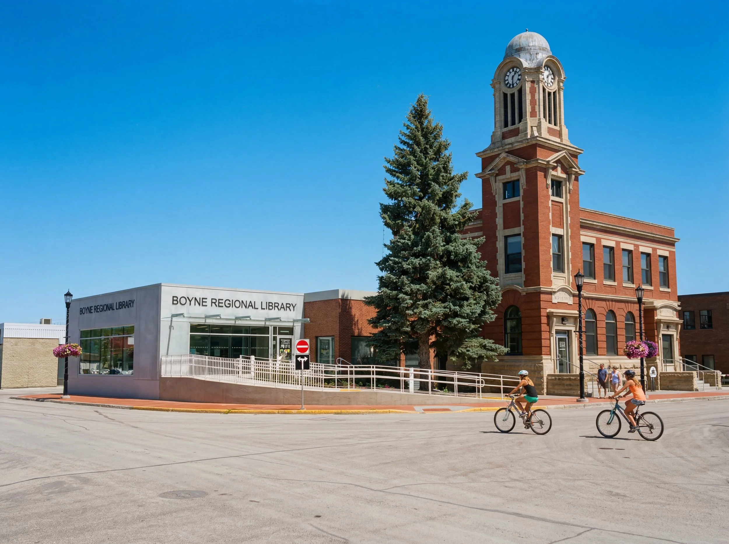 Empty interior room of the Boyne Regional Library with curved wall, large windows, and built-in shelves, possibly a library or study area, with a round carpeted section in the center and a suspended circular ceiling feature.