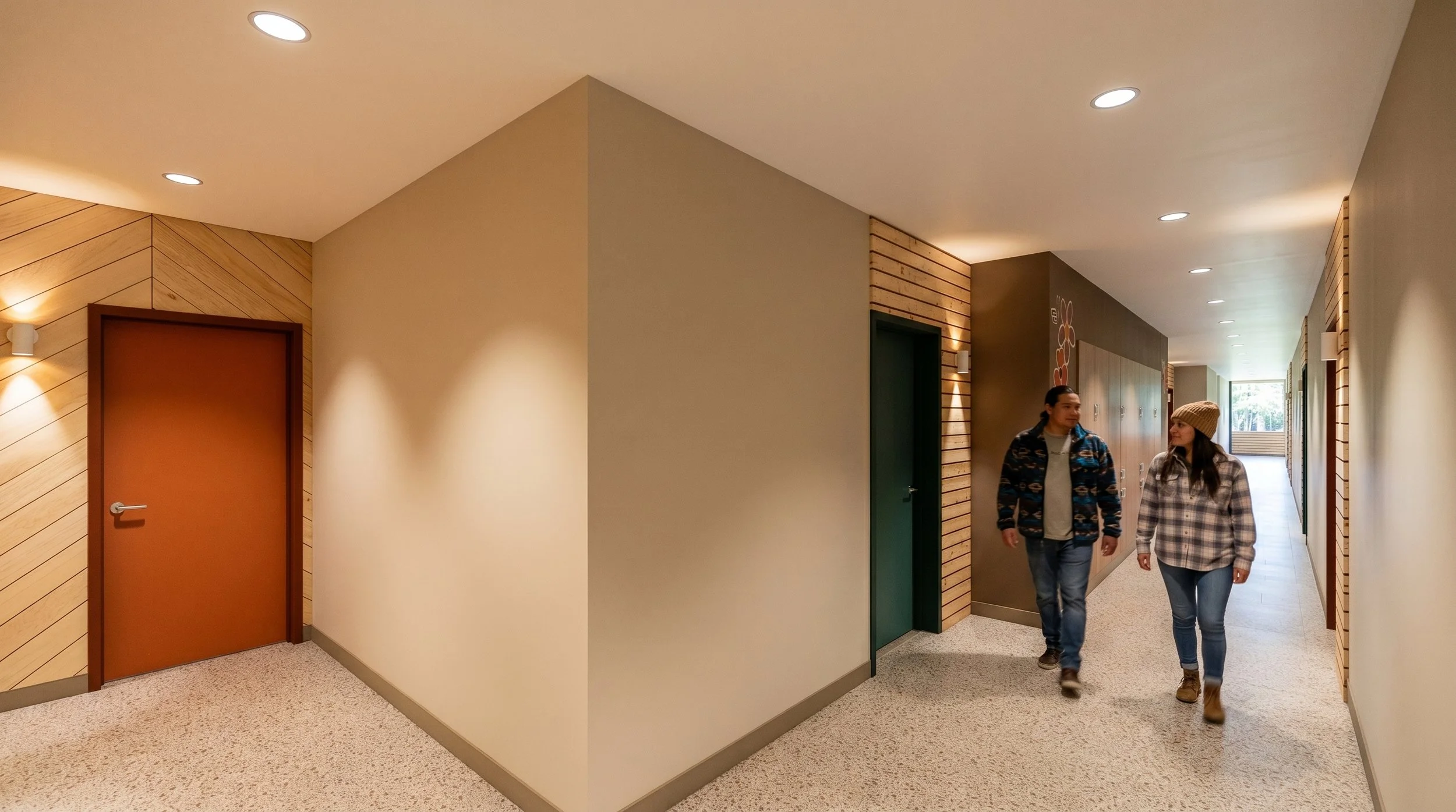 Hallway with beige walls, grass-green door, wooden wall accents, and lockers, illuminated by recessed ceiling lights, with a view of trees through a window at the end.