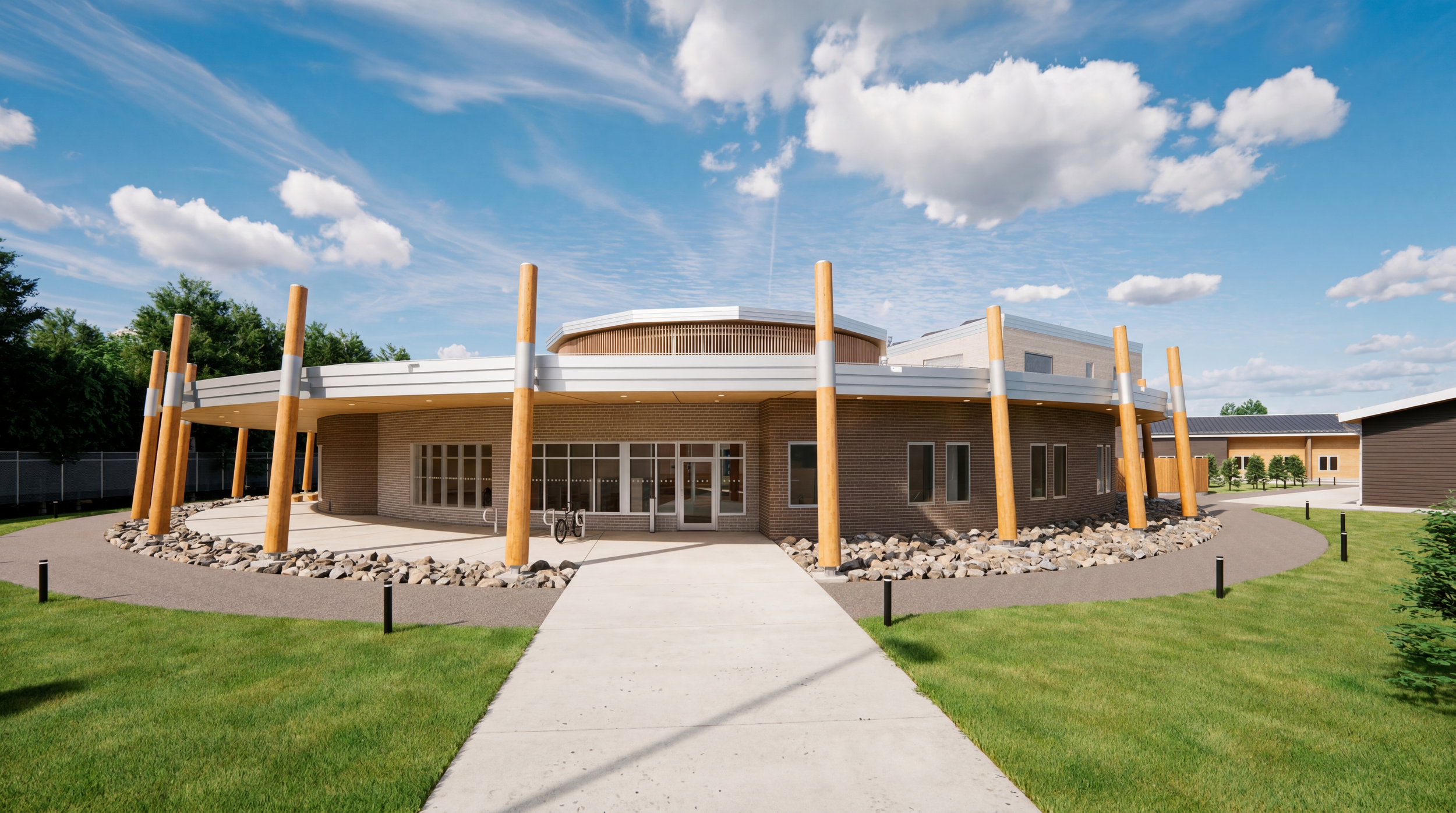 Architectural rendering of a modern building with a circular design, wooden supports, large windows, and a pathway leading to the entrance, set in a landscaped area with grass and trees under a partly cloudy sky for Bloodvein First Nation.