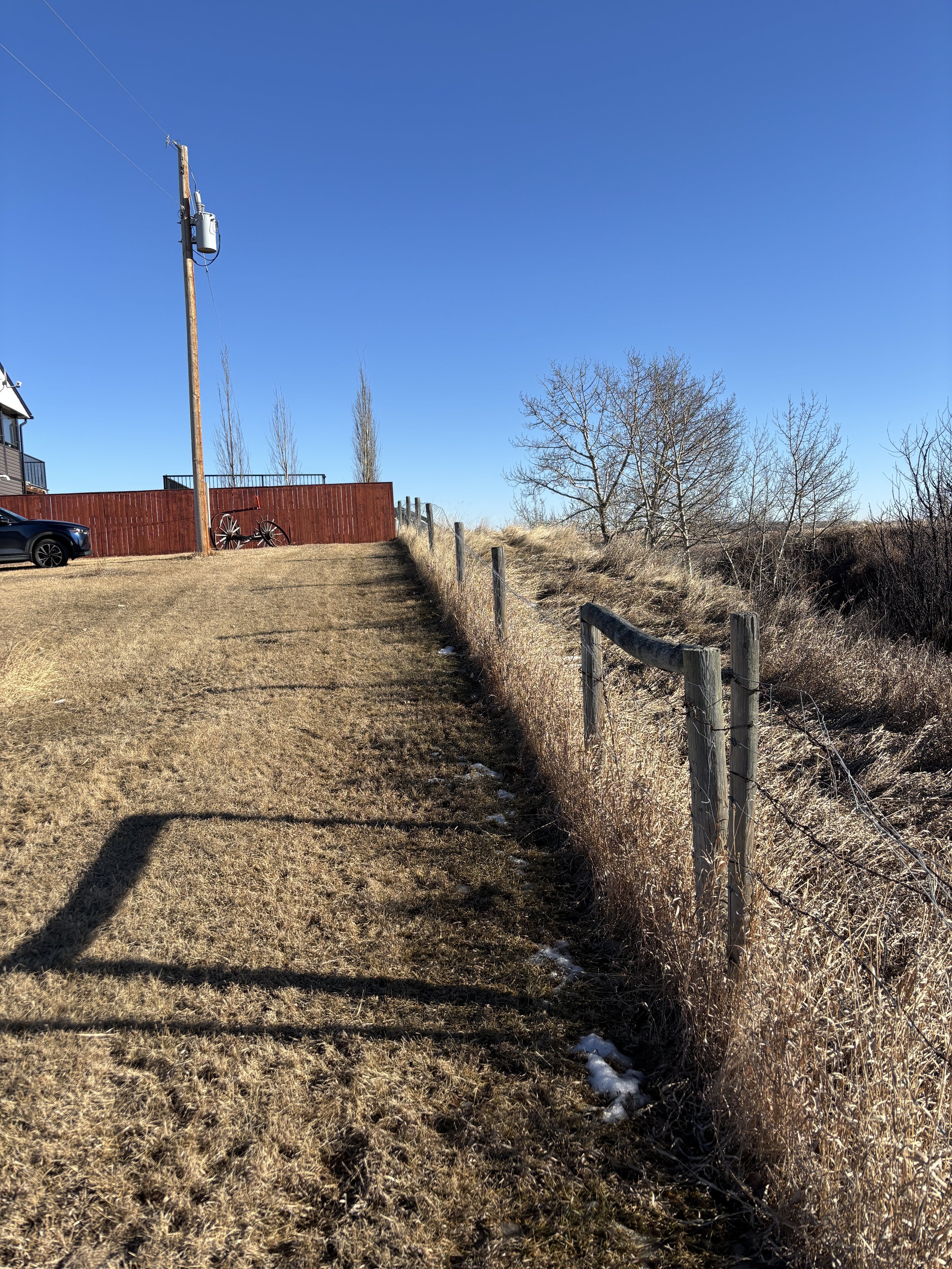 Photo 1 – Property Crest Review Visual reconnaissance along the property boundary near the slope crest to assess setback conditions, surface drainage, and visible signs of ground movement.