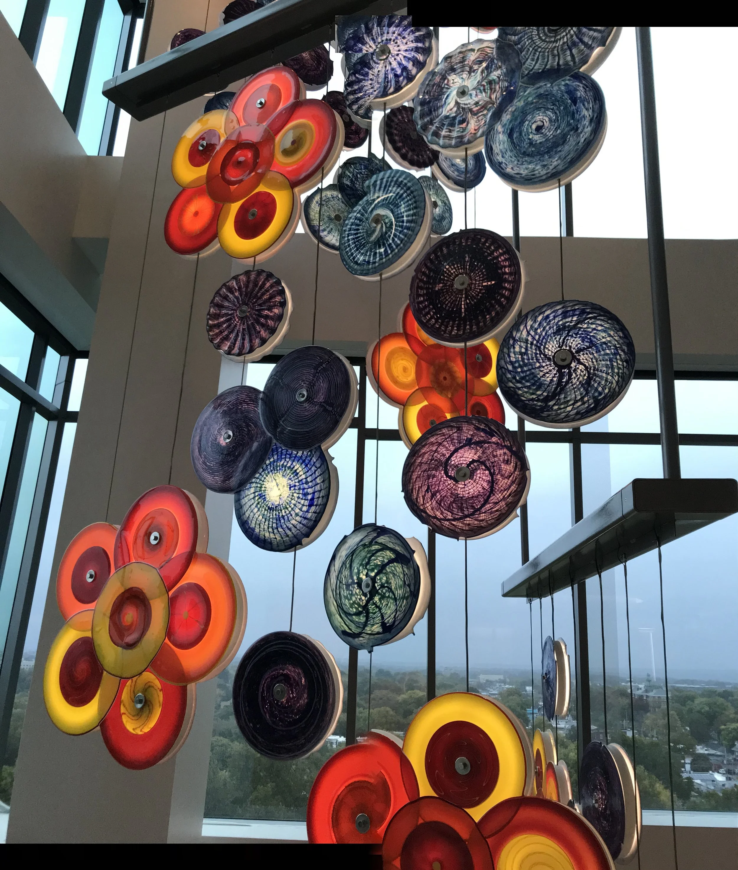 public art installation of illuminated fused glass rondels in a suspended canopy