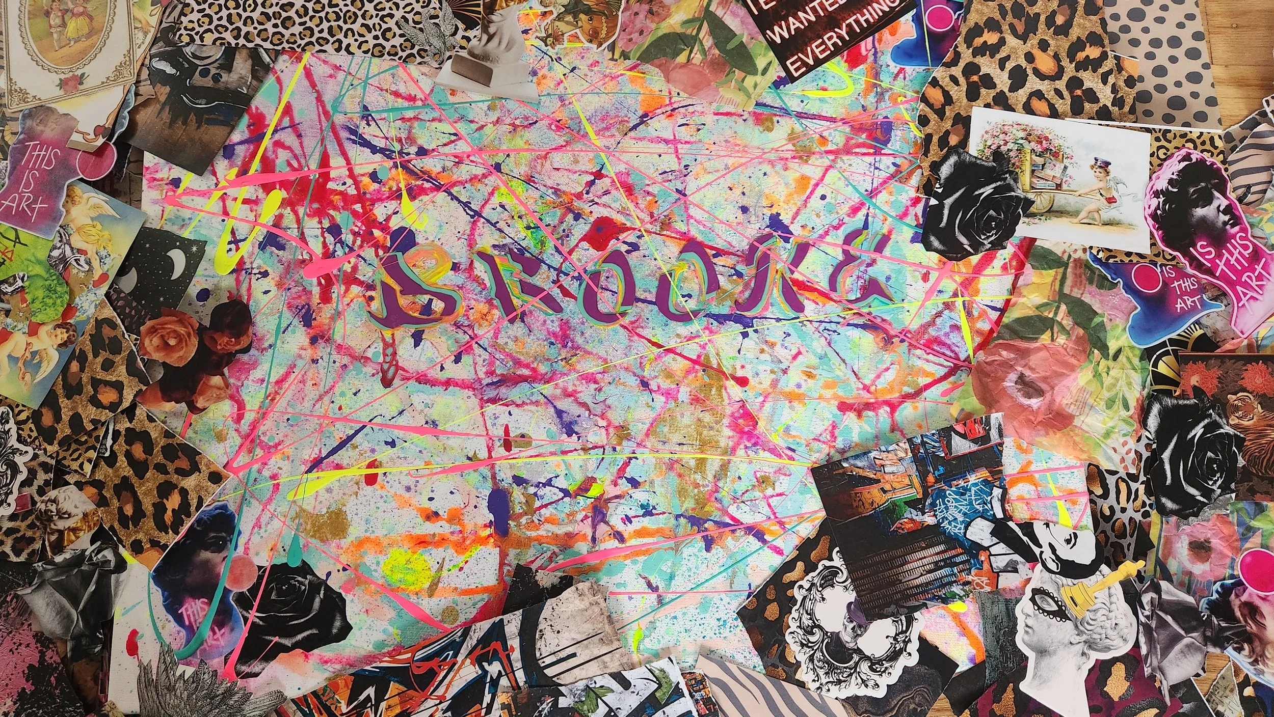 Multiple colorful canvases with abstract and graffiti-style art, covered in splashes, drips, and patterns, with multiple crayons scattered across the artworks on a pink and rainbow-colored surface.