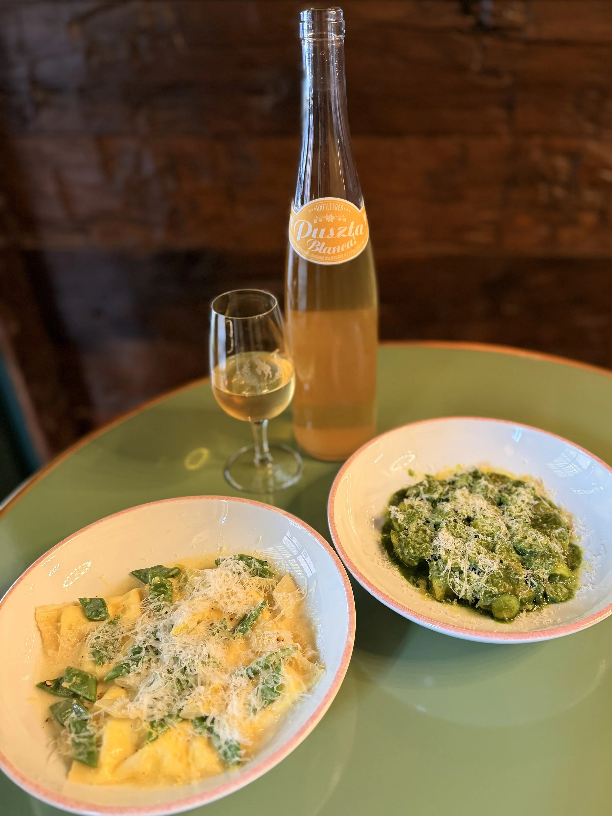 Two pasta dishes: the one on the left is the Agnolotti set with Romano beans, ricotta, and lemon, and on the right is the Potato Gnocchi set with smoked parsley pureé, parmesan, and baby zucchini. 