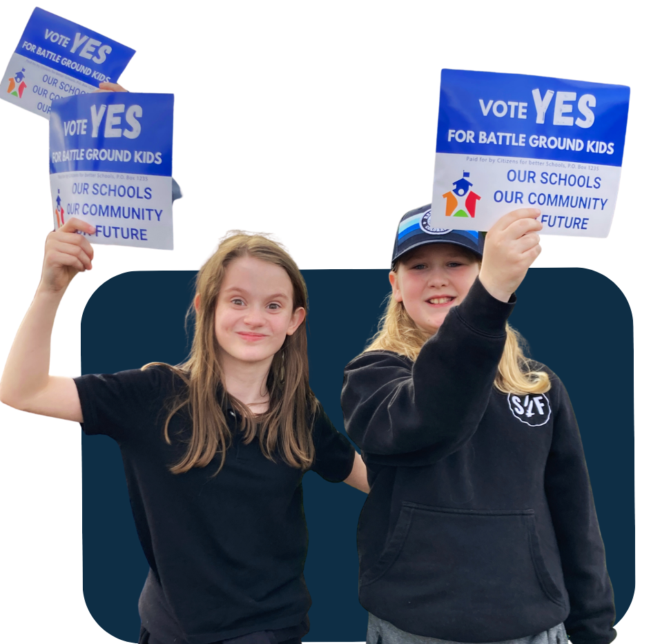 Two young girls holding signs that say "VOTE YES FOR BATTLE GROUND KIDS," "OUR SCHOOLS," "OUR COMMUNITY," and "OUR FUTURE," at a rally or event advocating for children and education.