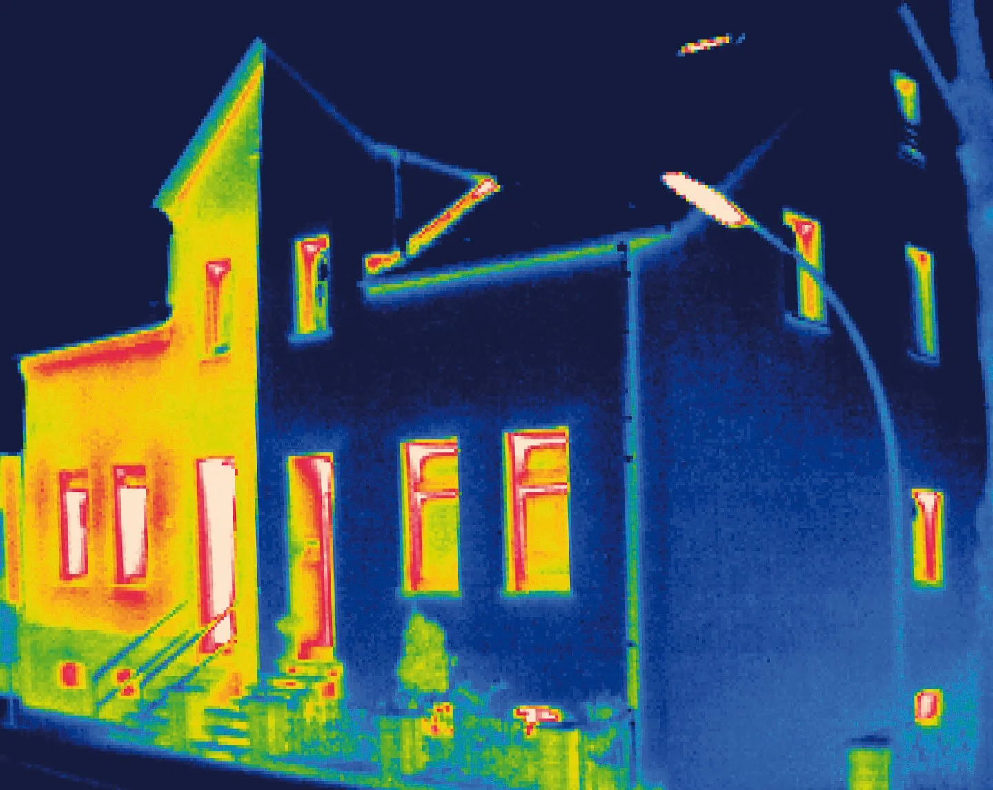 Thermografisches Bild eines Hauses, zeigt unterschiedliche Oberflächentemperaturen in bunten Farben.