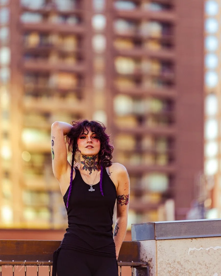Full-length rooftop portrait of a tattoo artist in black clothing during a personal branding session by Denver photographer Jessica Dnea Imagery.