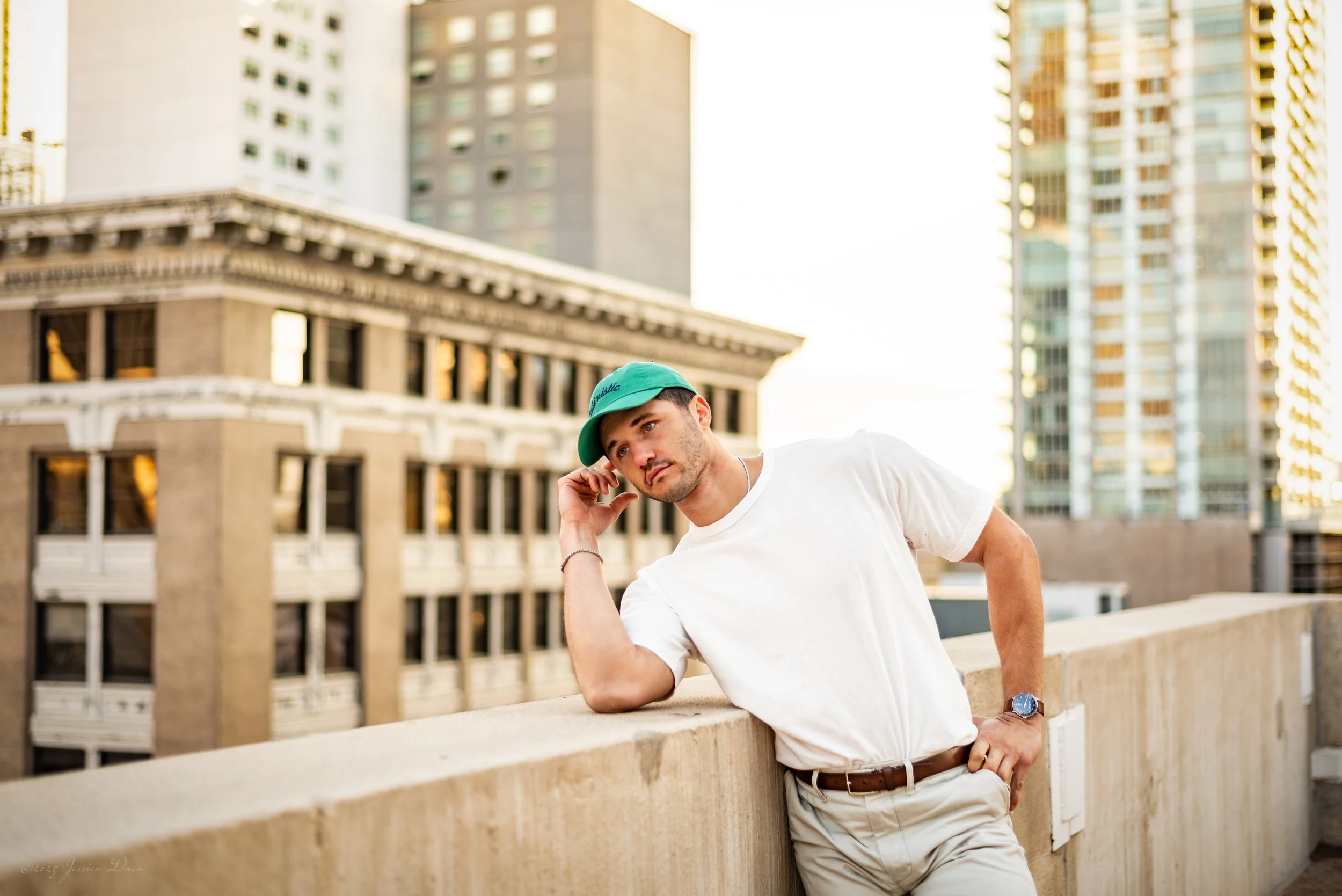 Downtown Denver lifestyle portrait on a rooftop with warm natural light, city architecture, relaxed posing, and professional imagery for personal branding and social media.