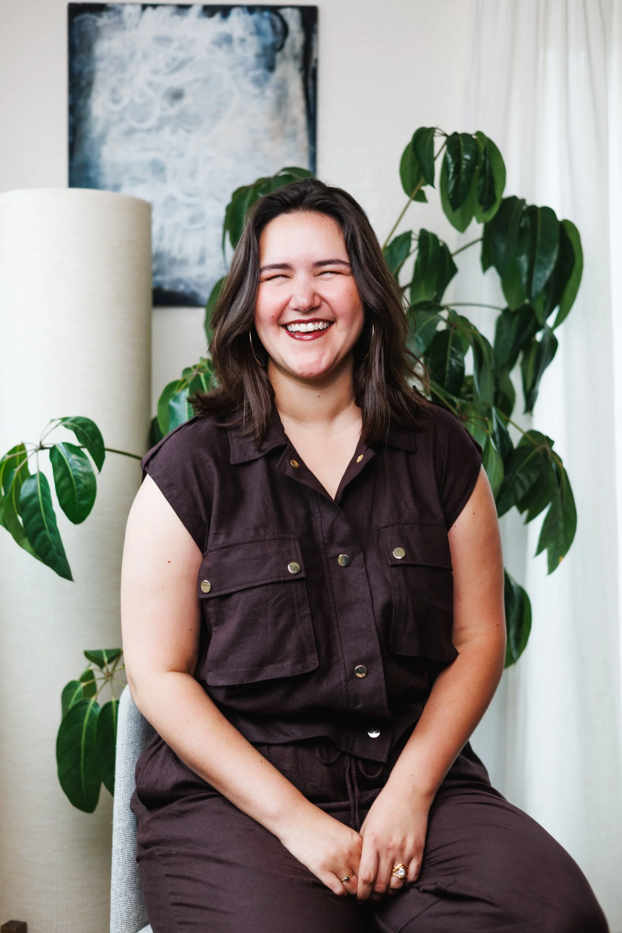 Relaxed individual Lyyra promo portrait in a plant-filled home studio photographed for artist branding.