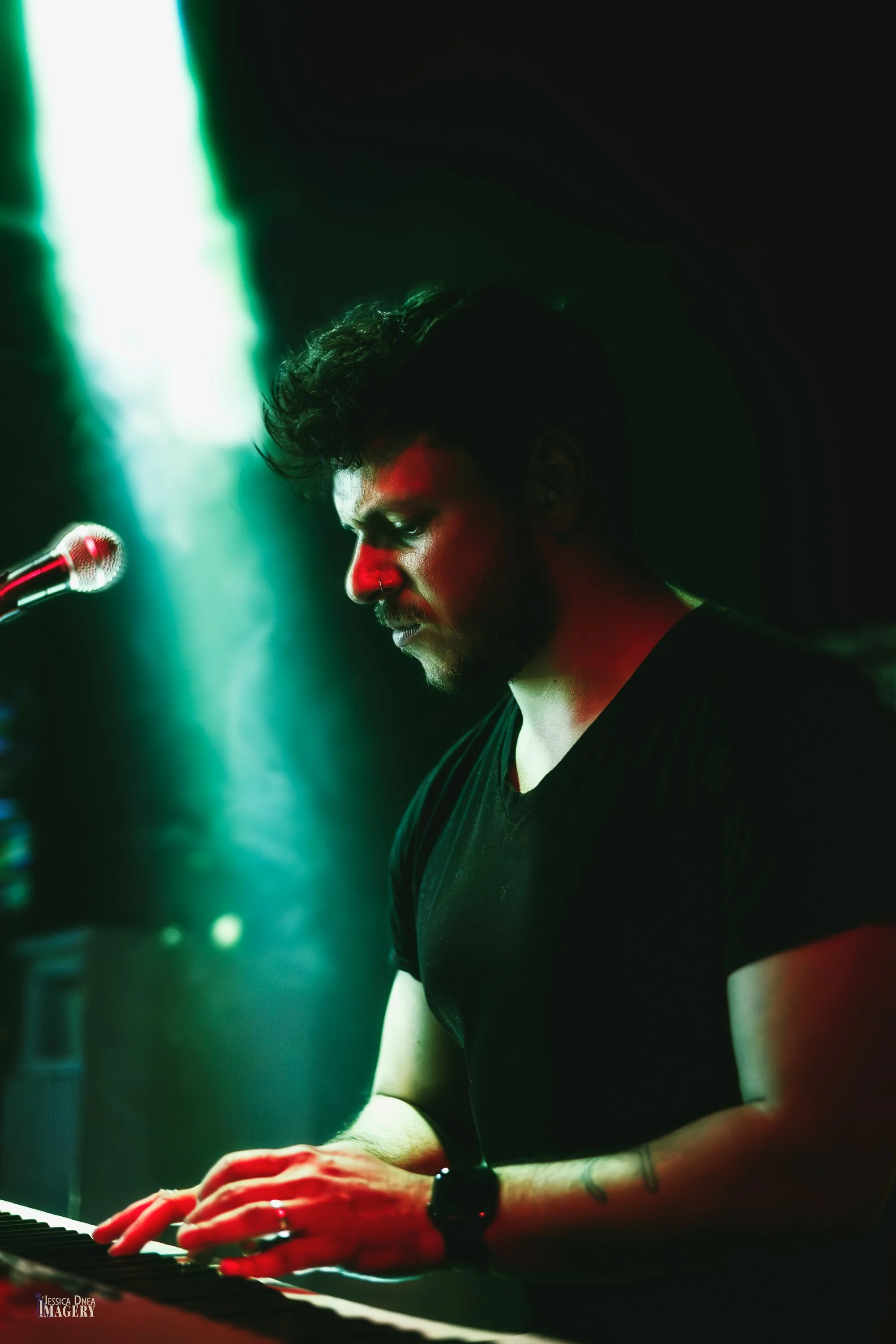 Phooey’s keyboardist performs in profile beneath green stage lighting during a live band set at Lost Lake in Denver.