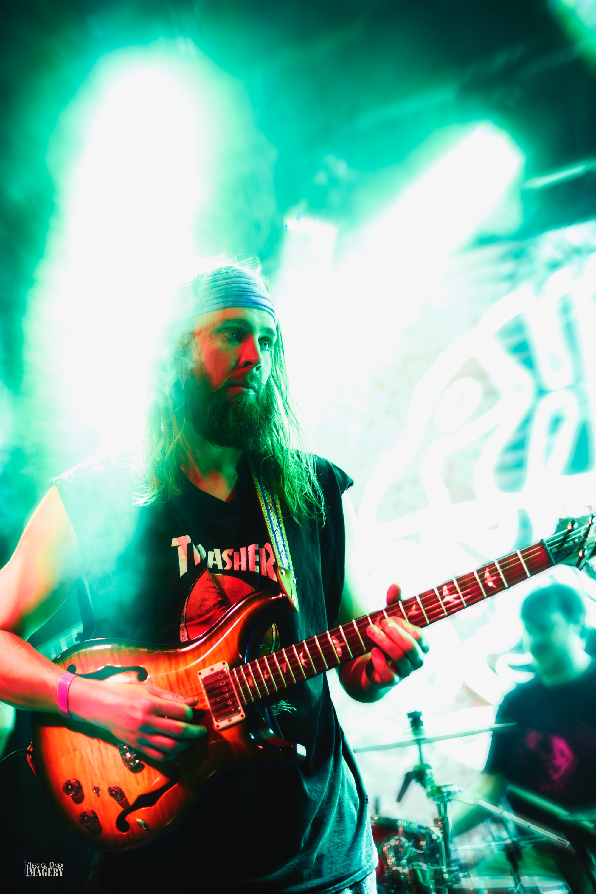 Phooey’s long-haired guitarist plays through dense green and white stage fog during a live performance at Lost Lake in Denver.