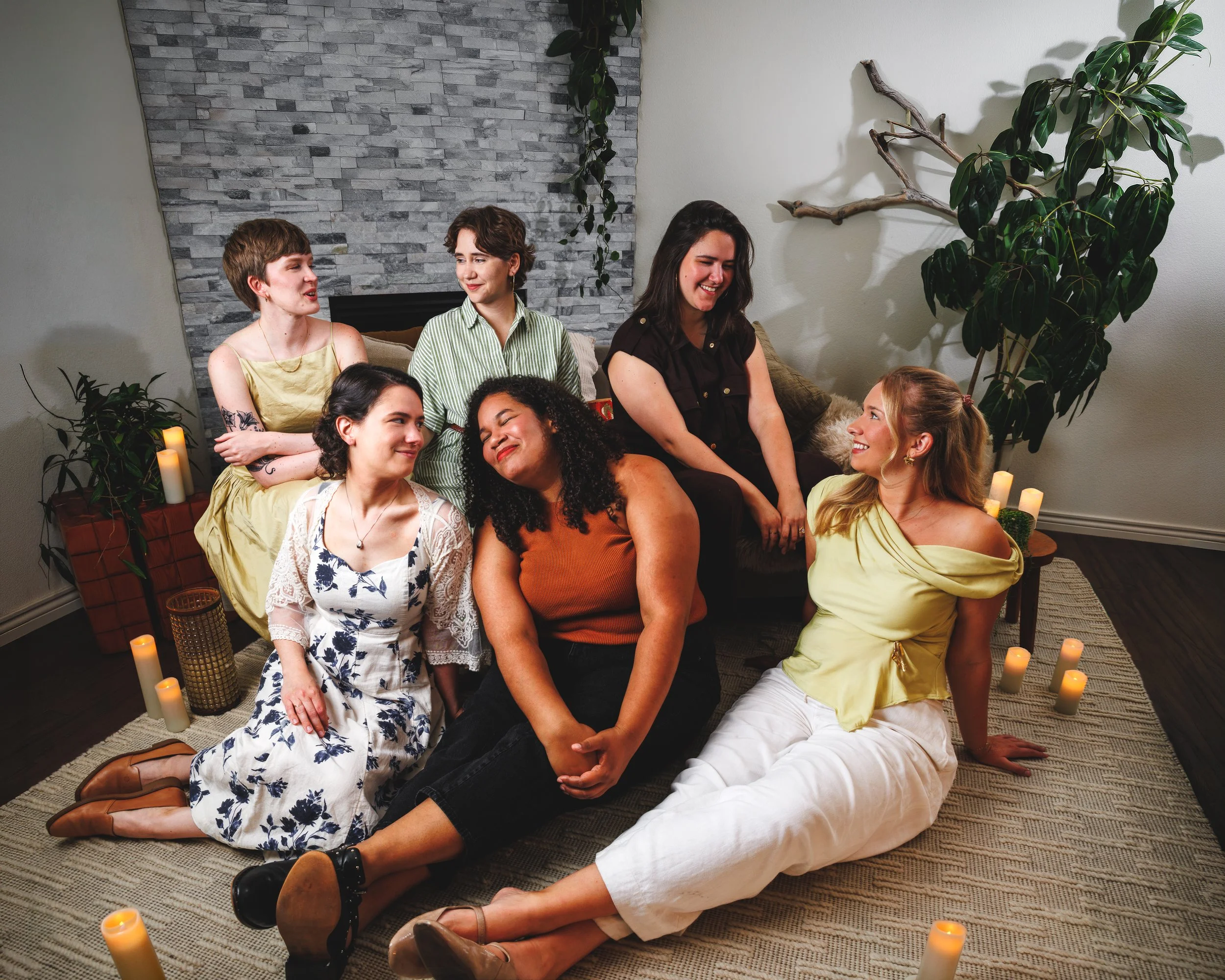 Six-member creative team posed together in a styled indoor space with plants and candles during a group branding session by Jessica Dnea Imagery.