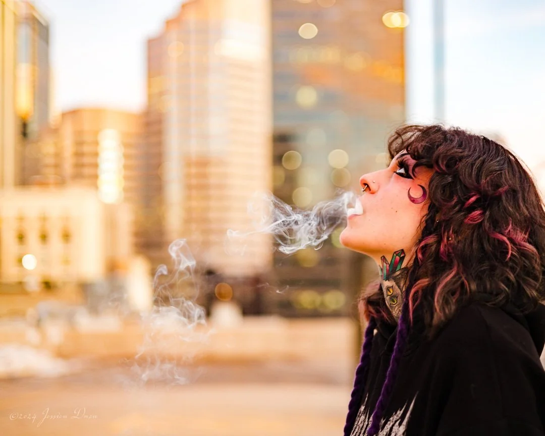 Creative downtown Denver portrait with city lights, warm sunset tones, expressive styling, and smoke for personal branding, artist portraits, and promotional photography.