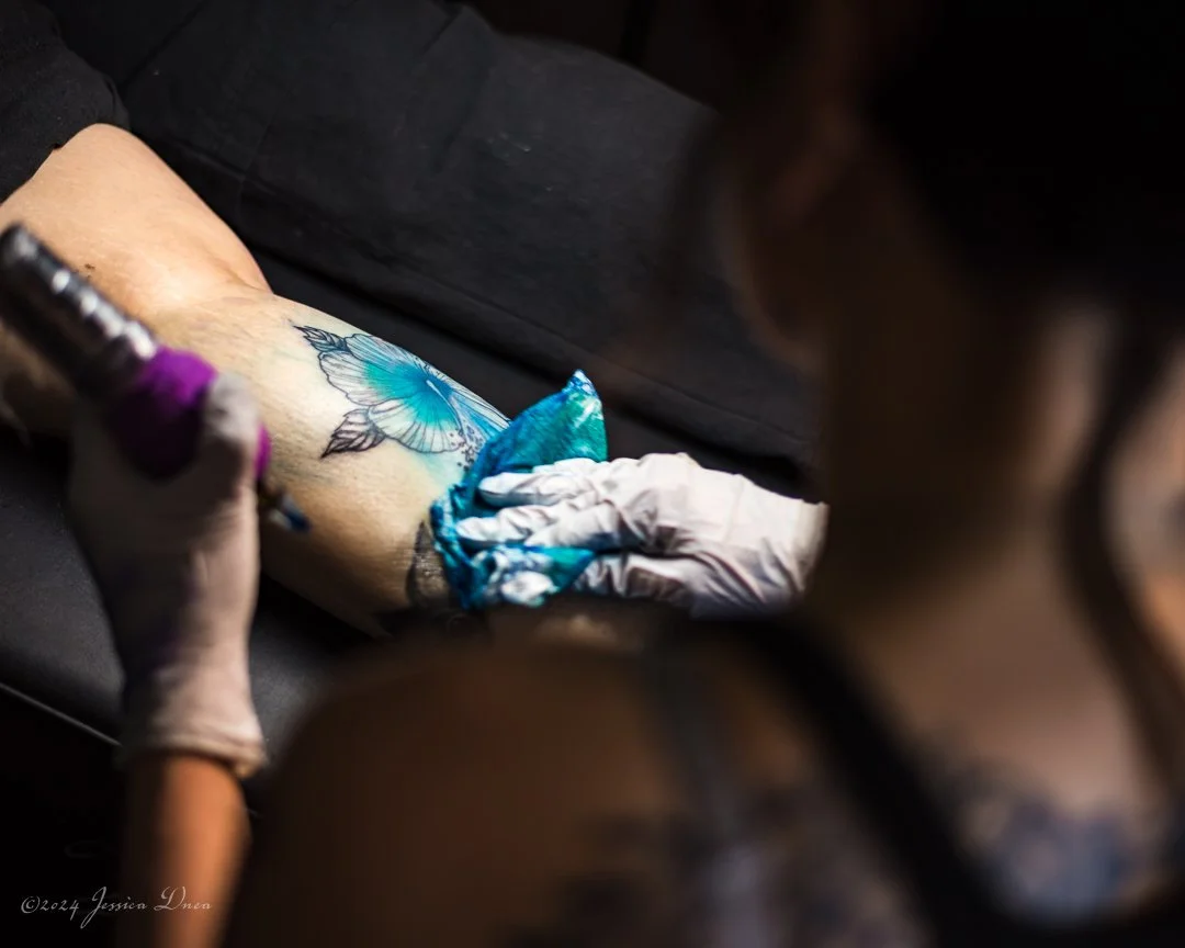 Denver personal branding photograph showing a tattoo artist working on a colorful tattoo, with close-up process details for business storytelling, websites, social media, and promotional content.
